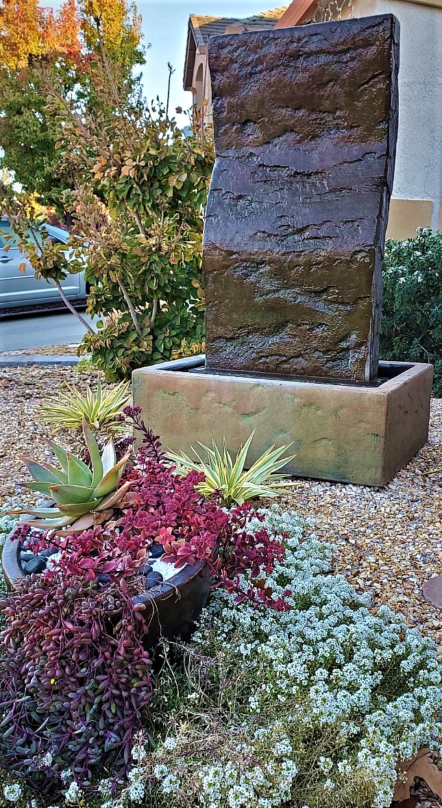 Stone block fountain with succulents at base