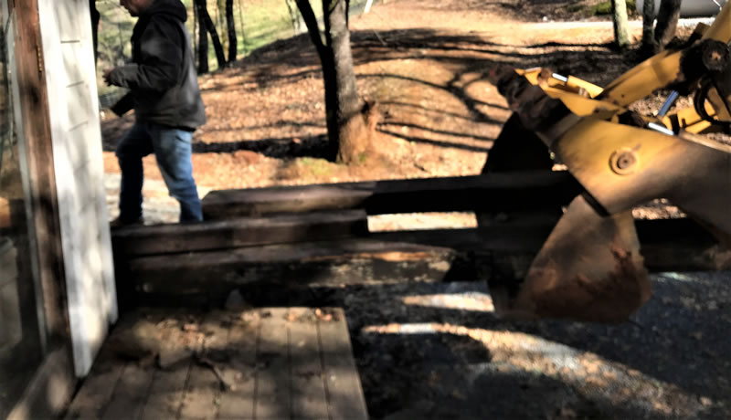 Backhoe and lumber pile on the ground