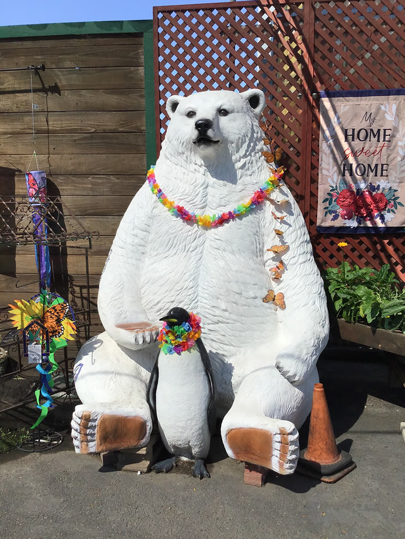 Big white polar bear seated with penguin, garden art