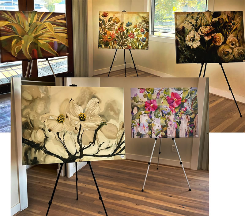 Colorful paintings of plants and garden scenery displayed on easels in a shop. 