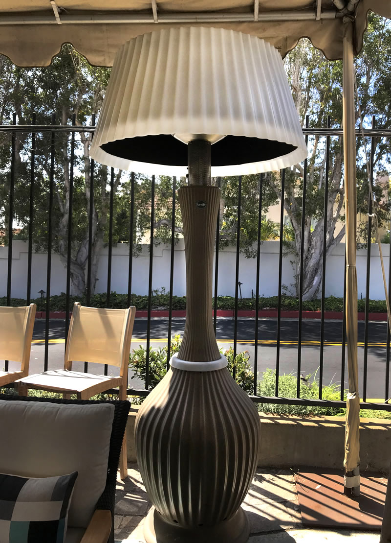 Tall outdoor light or heater with large lampshade.