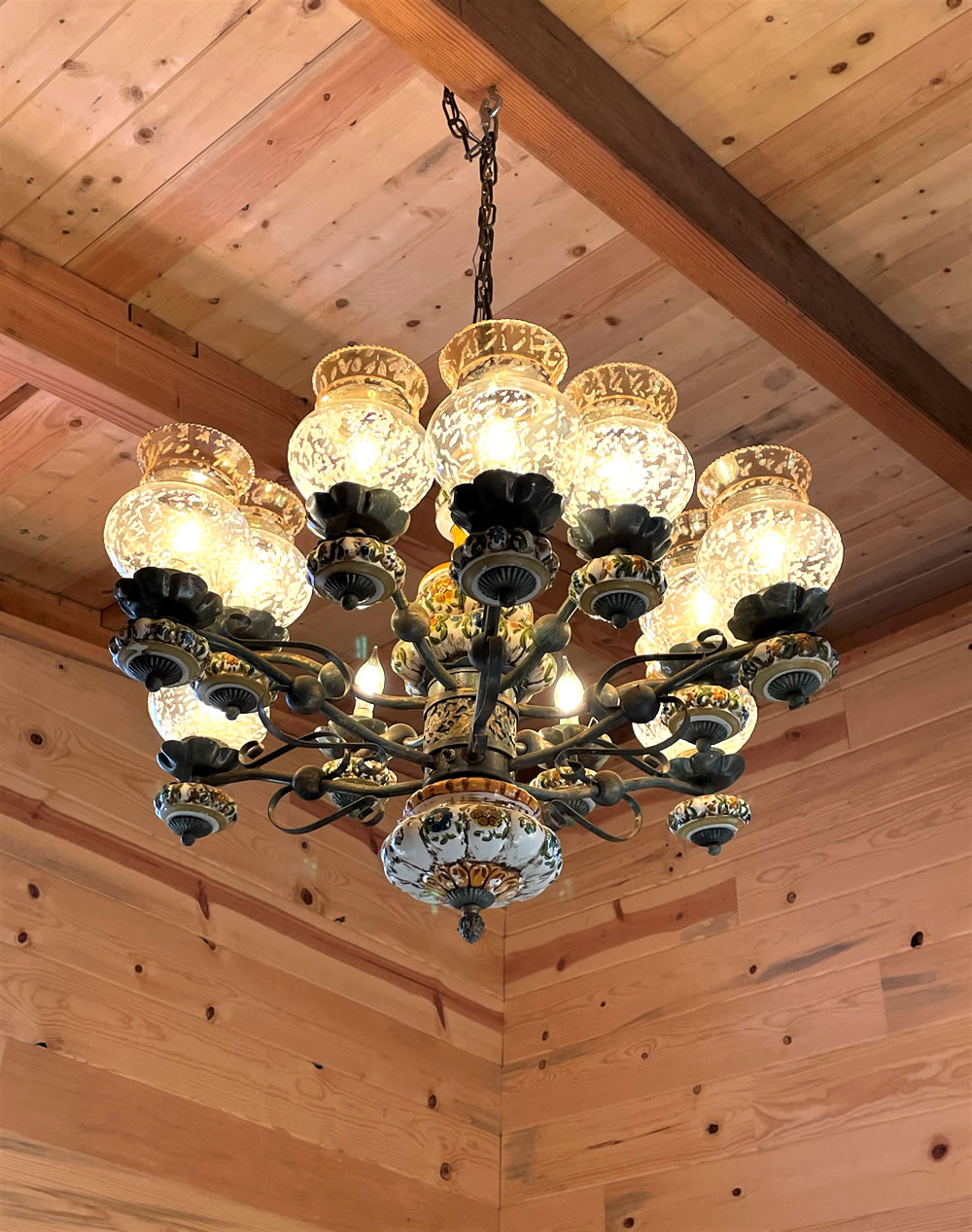 Chandelier hanging from wood-beamed ceiling. 