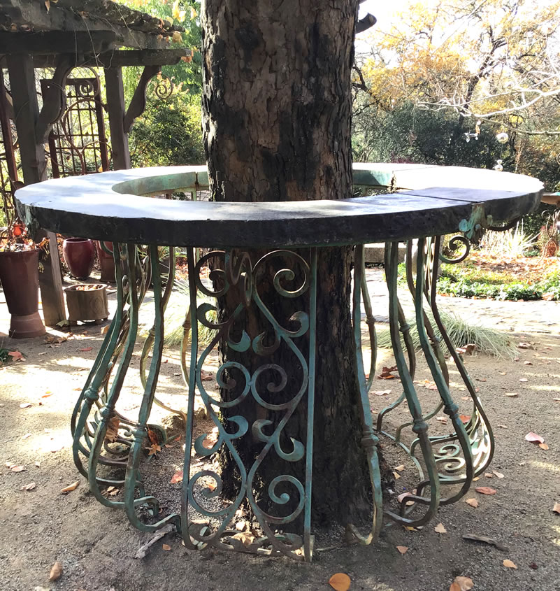 Wrought iron circular table with cutout center for large tree trunk