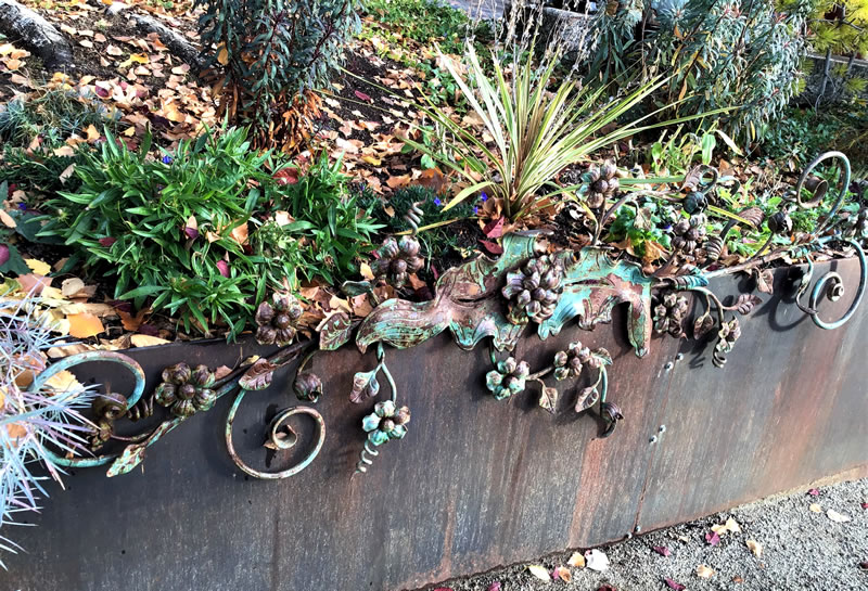 Wrought iron scrollwork along edge of low metal wall.